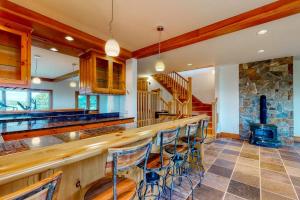 a kitchen with a bar and a stone fireplace at Delightful oceanfront home with amazing views, wrap-around deck & two fireplaces in Wiscasset