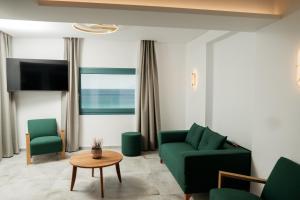 a living room with a green couch and a table at Villa Gonates in Limenaria