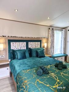 ein Schlafzimmer mit einem großen Bett mit einer grünen Bettdecke in der Unterkunft The Lodge-Static Holiday Lodge in Carnforth