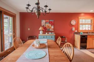 a kitchen and dining room with a wooden table and chairs at Gorgeous lakefront home w/ dock, canoe, kayaks & lake/forest views in Ellsworth