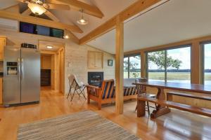 a kitchen and dining room with a table and refrigerator at Luxe Bayfront Cabin w/ Stunning Views & Shared Dock- Ideal for Hunting & Fishing in Bowdoinham