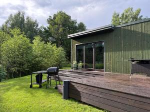 ein Haus mit einer Holzterrasse mit Grill in der Unterkunft SikaSpot Green in Sika