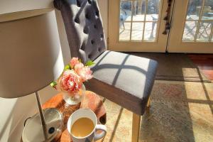 a room with a table with a vase of flowers and a chair at Classic home with prime location 1 block from Main Street in Bucksport