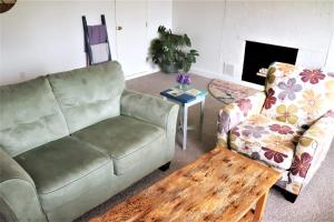a living room with a couch and a coffee table at Ocean-view cottage near beach with deck, grill, & full kitchen in Bristol