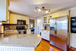 a large kitchen with a stainless steel refrigerator at Classic home with prime location 1 block from Main Street in Bucksport +33 photos