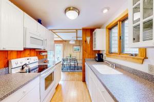 a kitchen with white cabinets and a counter top at Dog-friendly ocean-view home with grill, wood stove, deck, washer/dryer, & AC in Southwest Harbor