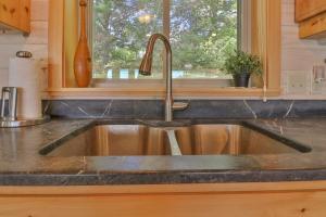 a kitchen sink in a kitchen with a window at Luxe Bayfront Cabin w/ Stunning Views & Shared Dock- Ideal for Hunting & Fishing in Bowdoinham +19 photos