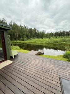 eine Holzterrasse mit Blick auf einen See in der Unterkunft SikaSpot Green in Sika