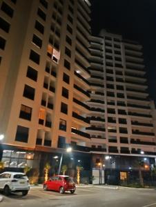 two cars parked in a parking lot in front of a large building at Dani's Sea Breeze in Oran
