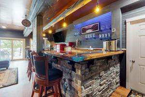 a bar in a restaurant with a stone wall at Luxurious waterfront home with deck, firepit, hot tub, fireplace, & pool table in Boothbay +42 photos