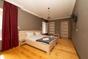 a bedroom with a bed and a red curtain at Varga Kvareli in Kvareli +61 photos