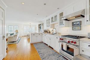 a kitchen with white cabinets and a stove top oven at Oceanfront home incredible ocean views, deck & location in Boothbay