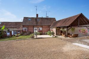 une maison avec un pavillon en face de celle-ci dans l'établissement Chambres d'hôte - Clos d'Allonne, à Beauvais