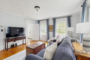 a living room with a couch and a tv at Elegant Historic Home with Refined Interiors and Private Outdoor Spaces in Camden