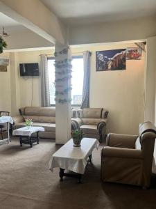 a living room with couches and tables in a room at Yasin Holiday Hotel in Gilgit