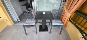 a black table and two chairs on a balcony at Torres del Sol-La Perla- Beachfront & Ocean View in Los Cristianos