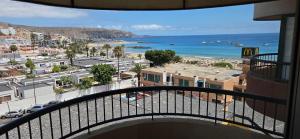 a balcony with a view of a city and the ocean at Torres del Sol-La Perla- Beachfront & Ocean View in Los Cristianos