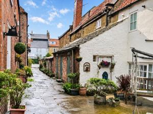 an alley in an old town with potted plants at Endeavour Cottage Whitby Quiet Old Yard Fishermans Cottage in Whitby