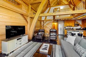 a living room with a couch and a tv in a cabin at The Cabin on 32 wooded acres - tranquil new-build with sauna & forested views in Franklin
