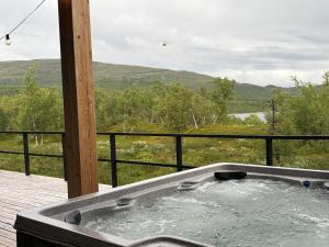 a jacuzzi tub on a deck with a view at Sunrise View Lapland, Jacuzzi and sky view in Kilpisjärvi