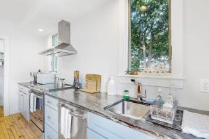 a white kitchen with a sink and a window at Waterfront, walkable home with beautiful kitchen & washer/dryer - dog-friendly in Camden