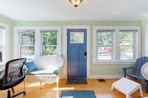 a living room with a blue door and windows at Charming Cottage with Cozy Comfort and Easy Access to Outdoor Adventures in North Lamoine