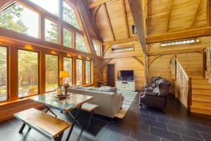a living room with a couch and a table at The Cabin on 32 wooded acres - tranquil new-build with sauna & forested views in Franklin +27 photos