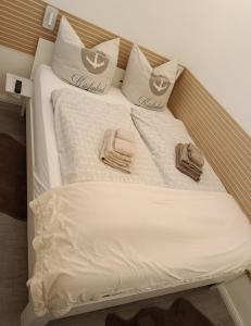 a bed with white sheets and pillows on it at Saltwater Hohwacht in Hohwacht