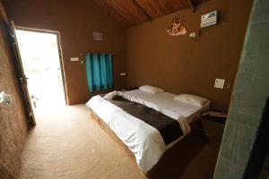 a bedroom with a bed in a room with a window at Rupani Dhani Farmhouse by Belmore in Mandkaula