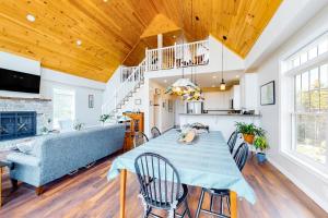 a dining room and living room with a table and a couch at Secluded hilltop home with beautiful Cadillac Mountain view and multiple decks in Bar Harbor