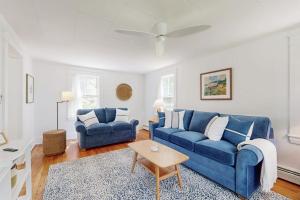 a living room with two blue couches and a table at Tranquil Seaside Cottage with Spectacular Views, Wifi & Washer/Dryer in Boothbay