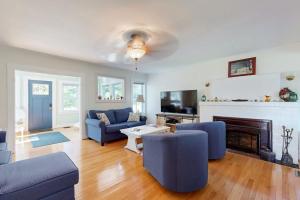 a living room with blue furniture and a fireplace at Charming Cottage with Cozy Comfort and Easy Access to Outdoor Adventures in North Lamoine
