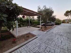 a pavilion with a car parked in a driveway at Sunset Bliss Apartments in Sarandë