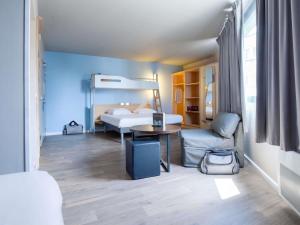 a room with a bedroom with a bed and a table at ibis budget Brest Centre Port in Brest +64 photos
