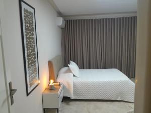 a bedroom with a bed and a night stand with a candle at Chez-moi wiss in Sfax