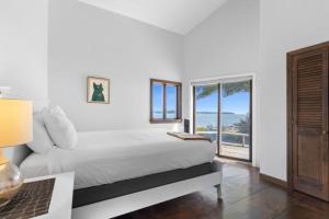 a white bedroom with a bed and a window at Clark Point Cottage, ocean access, panoramic views in Clark Island