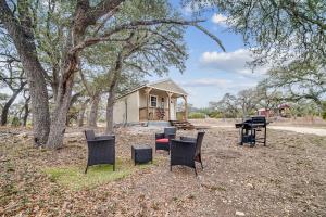 a group of chairs and a house with a grill at Hill Country Cabin 2 in Canyon Lake