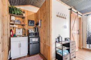 a kitchen with wooden walls and a counter with a stove at Hill Country Cabin 2 in Canyon Lake