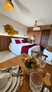 a hotel room with two beds and a table with flowers at Pousada Recanto do Luar in Serra de São Bento