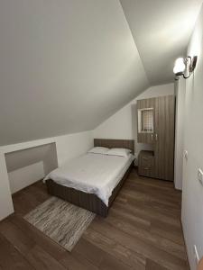 a white bedroom with a bed and wooden floors at Casa Todor Fundata in Fundăţica