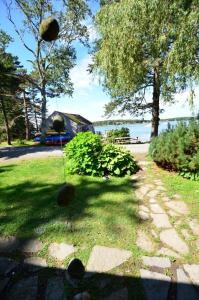 a yard with trees and a house in the background at Berry Cottage, private dock, overlooking a sandy b in South Thomaston
