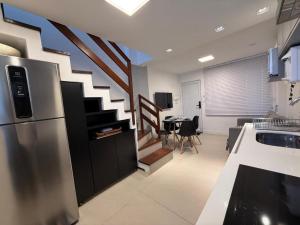 a kitchen with a staircase leading to a dining room at Triplex Luxo 2 Qtos c Churrasqueira na Rua das Pedras in Búzios +36 photos