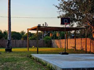 a basketball hoop in a park with a fence at Bilene Harmony Home in Vila Praia Do Bilene