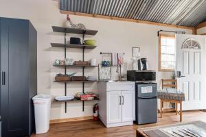 a kitchen with white cabinets and a black refrigerator at Hill Country Cabin 3 in Canyon Lake