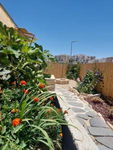 a garden with colorful flowers and a fence at וילה אושר in Mitzpe Ramon