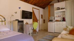 a bedroom with a bed and a kitchen with a microwave at Coqueto estudio con terraza in La Zubia