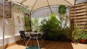 a patio with a table and chairs and plants at Coqueto estudio con terraza in La Zubia +2 photos