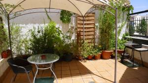 a patio with a table and a bunch of plants at Coqueto estudio con terraza in La Zubia
