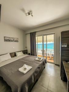 a bedroom with a bed and a view of the ocean at Joanna Apartments in Haraki