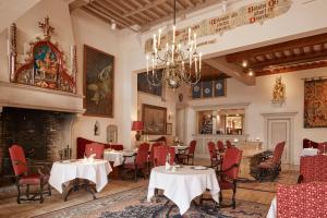 a restaurant with tables and chairs and a fireplace at Grand Hotel en Résidence De Draak in Bergen op Zoom